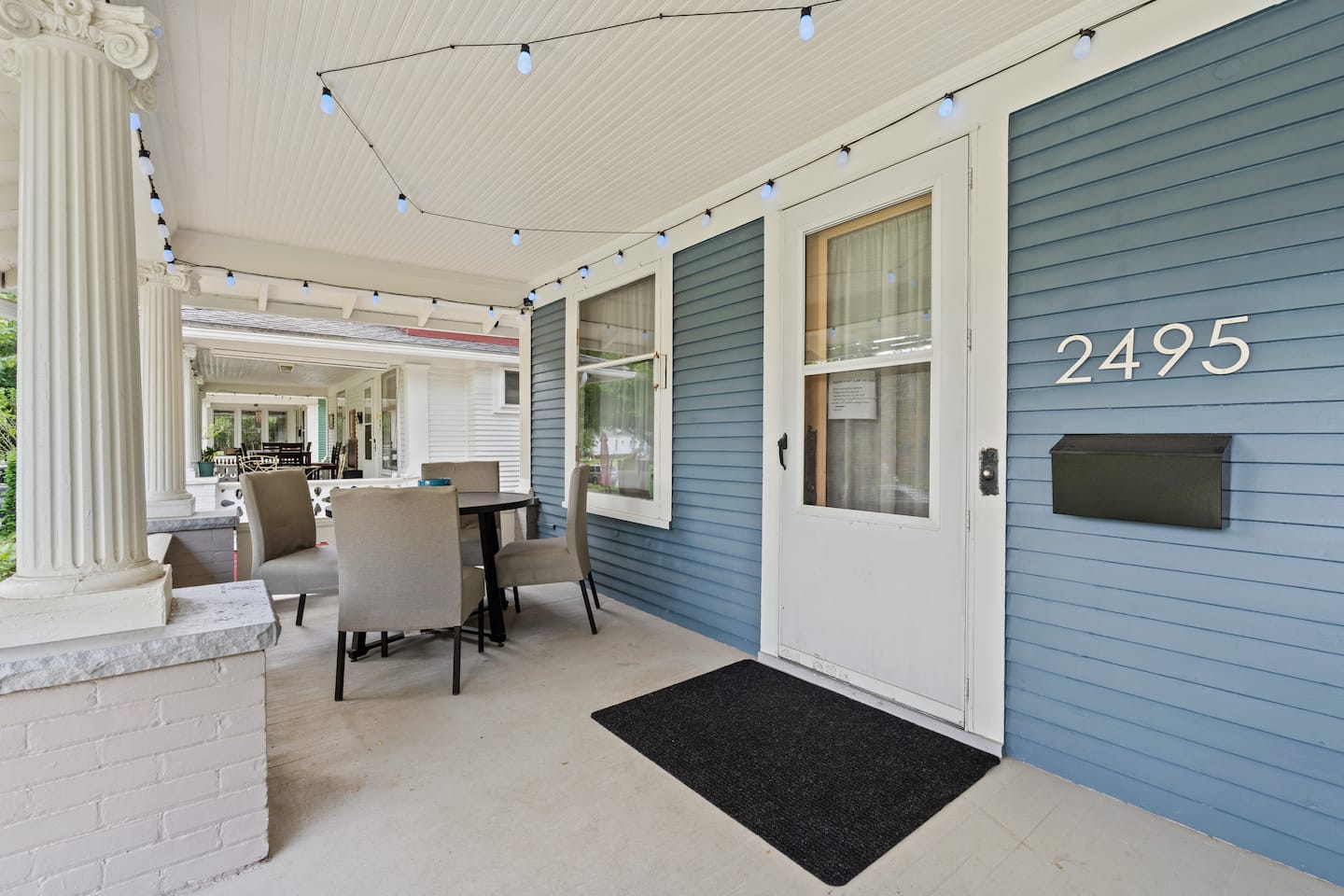 Blue siding, white wood trim and original columns on the porch of The Katie Lee, Tom’s rental in Toledo’s Old West End